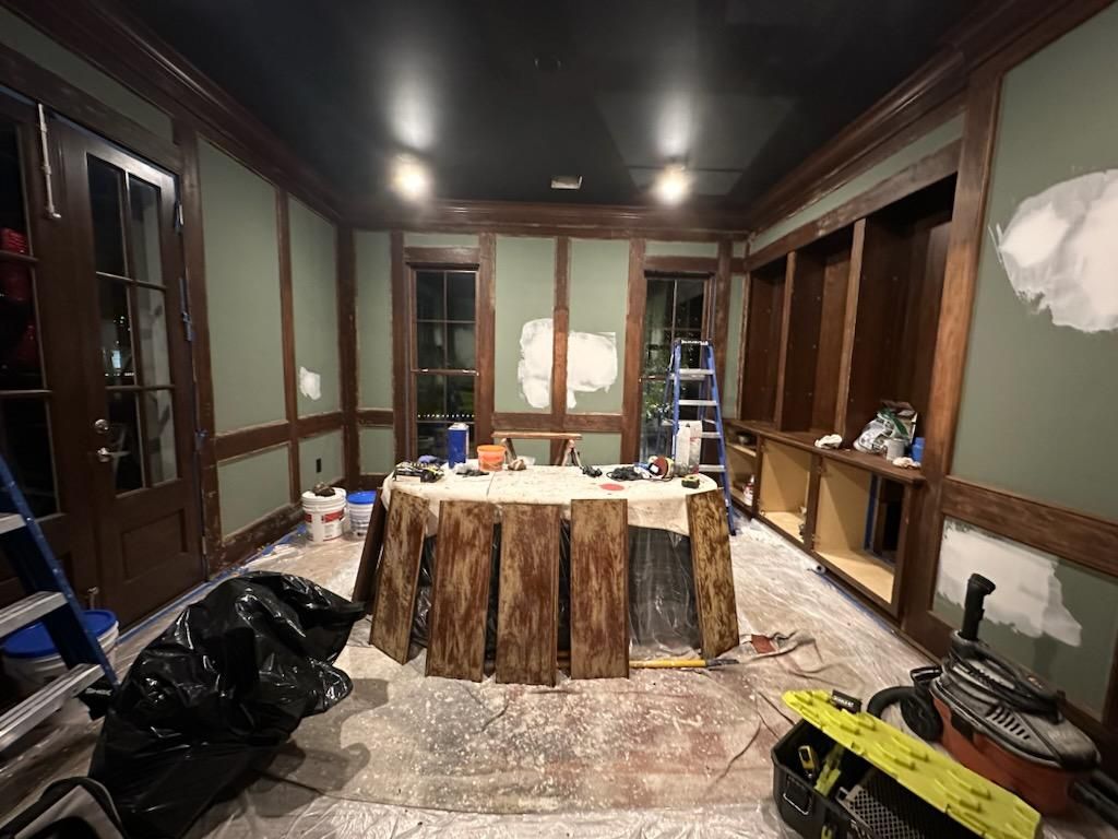 A room with a table and a ladder in it is being remodeled.