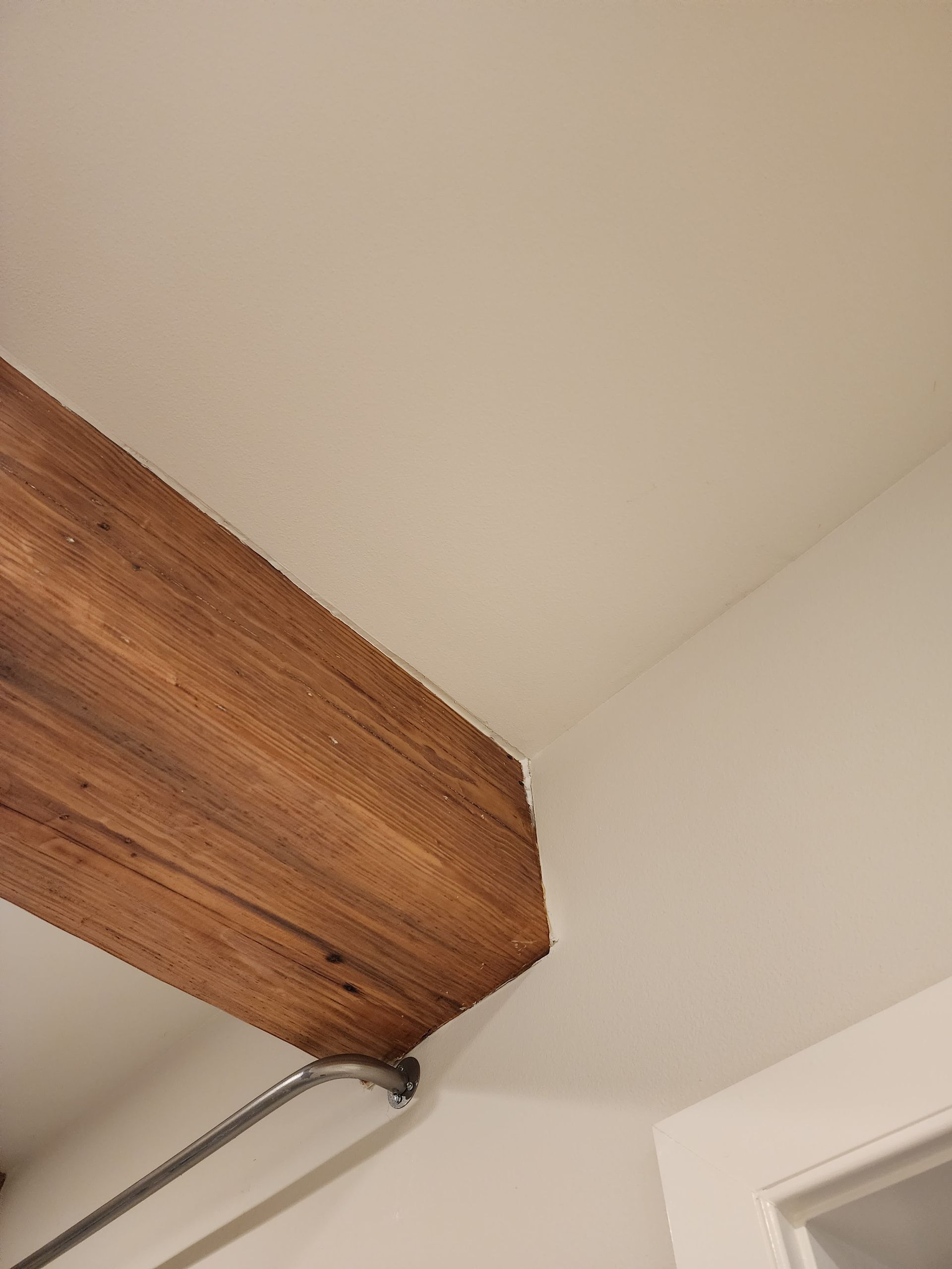 A wooden beam is hanging from the ceiling of a room.