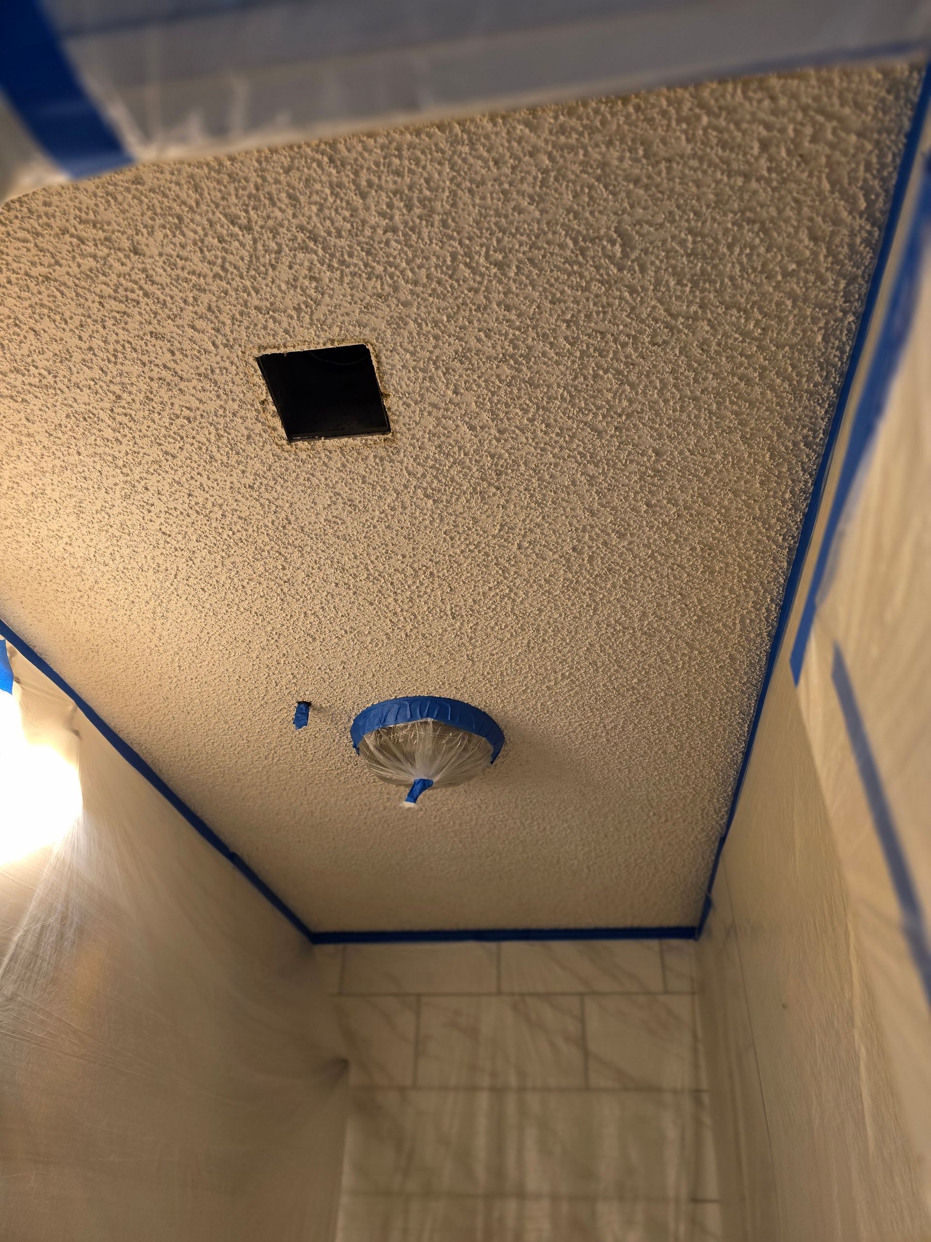 A bathroom with a ceiling that has a hole in it