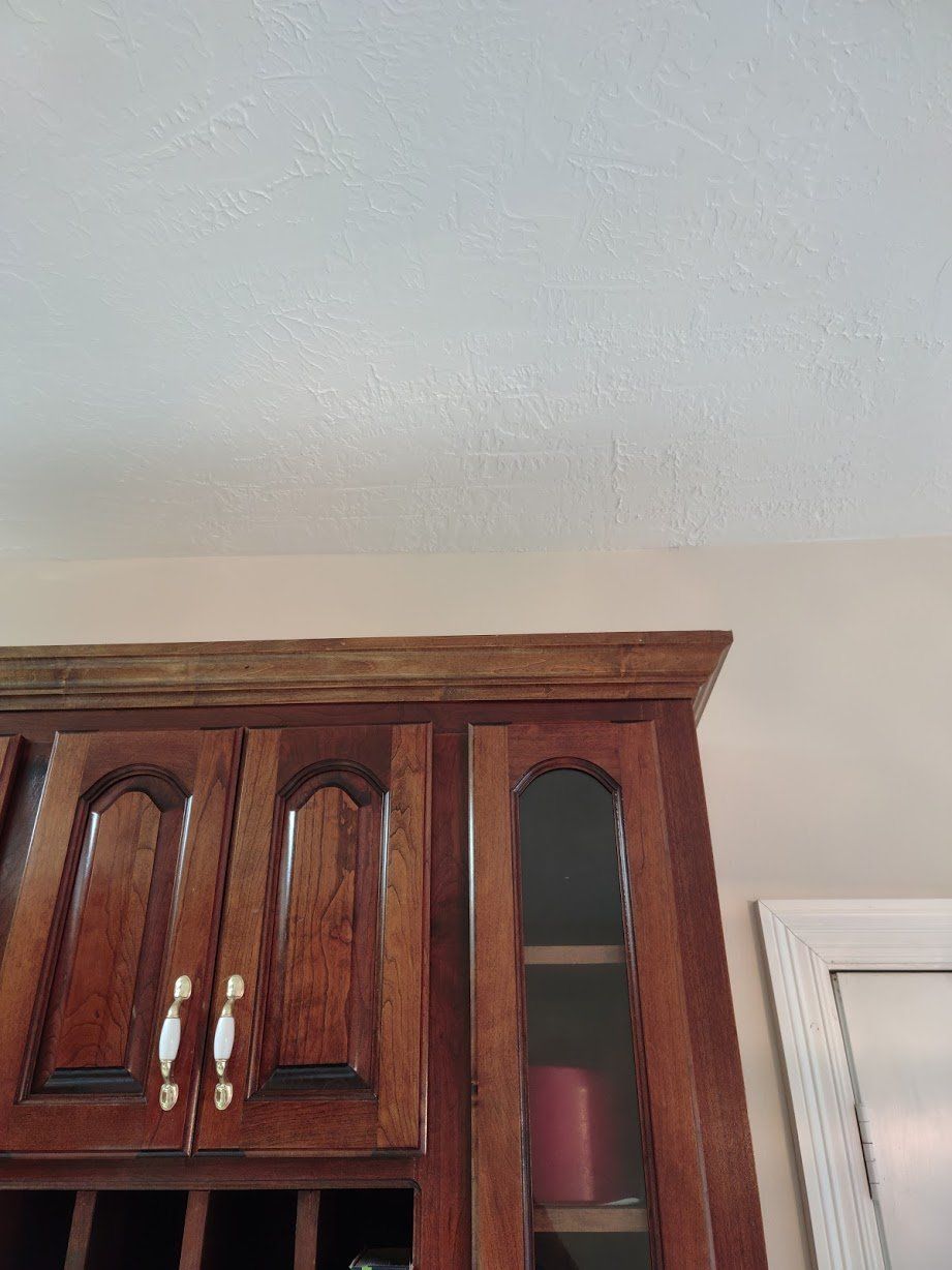 A kitchen with wooden cabinets and a white ceiling.