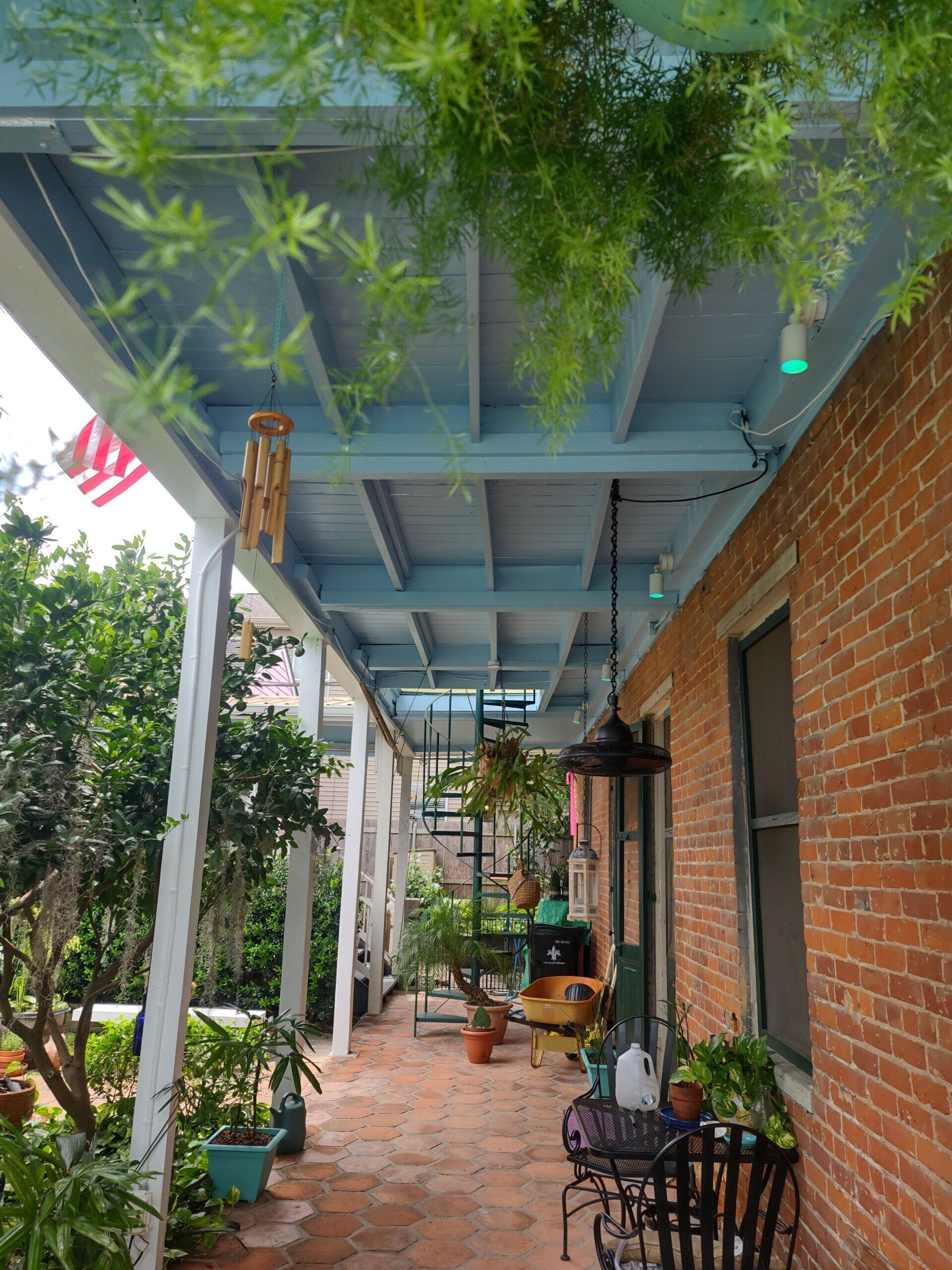 A brick house with a porch with a blue roof
