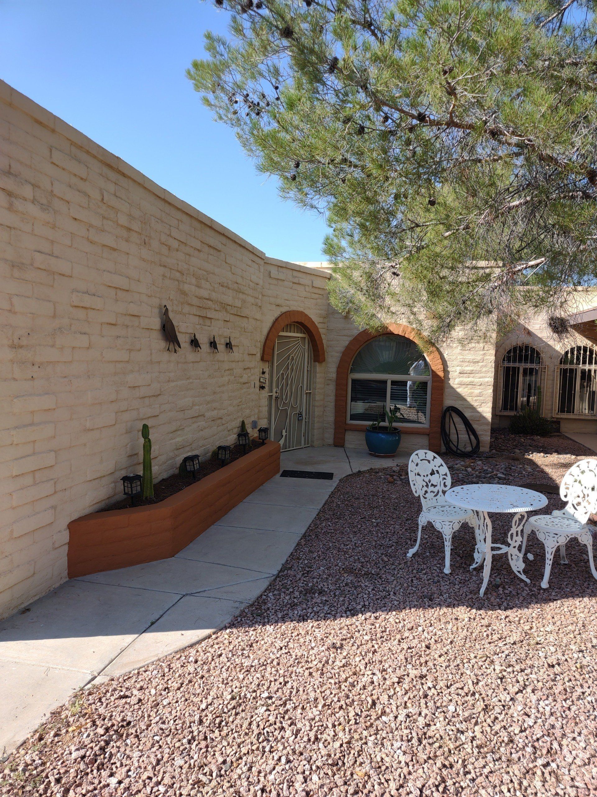 A brick building with a table and chairs in front of it