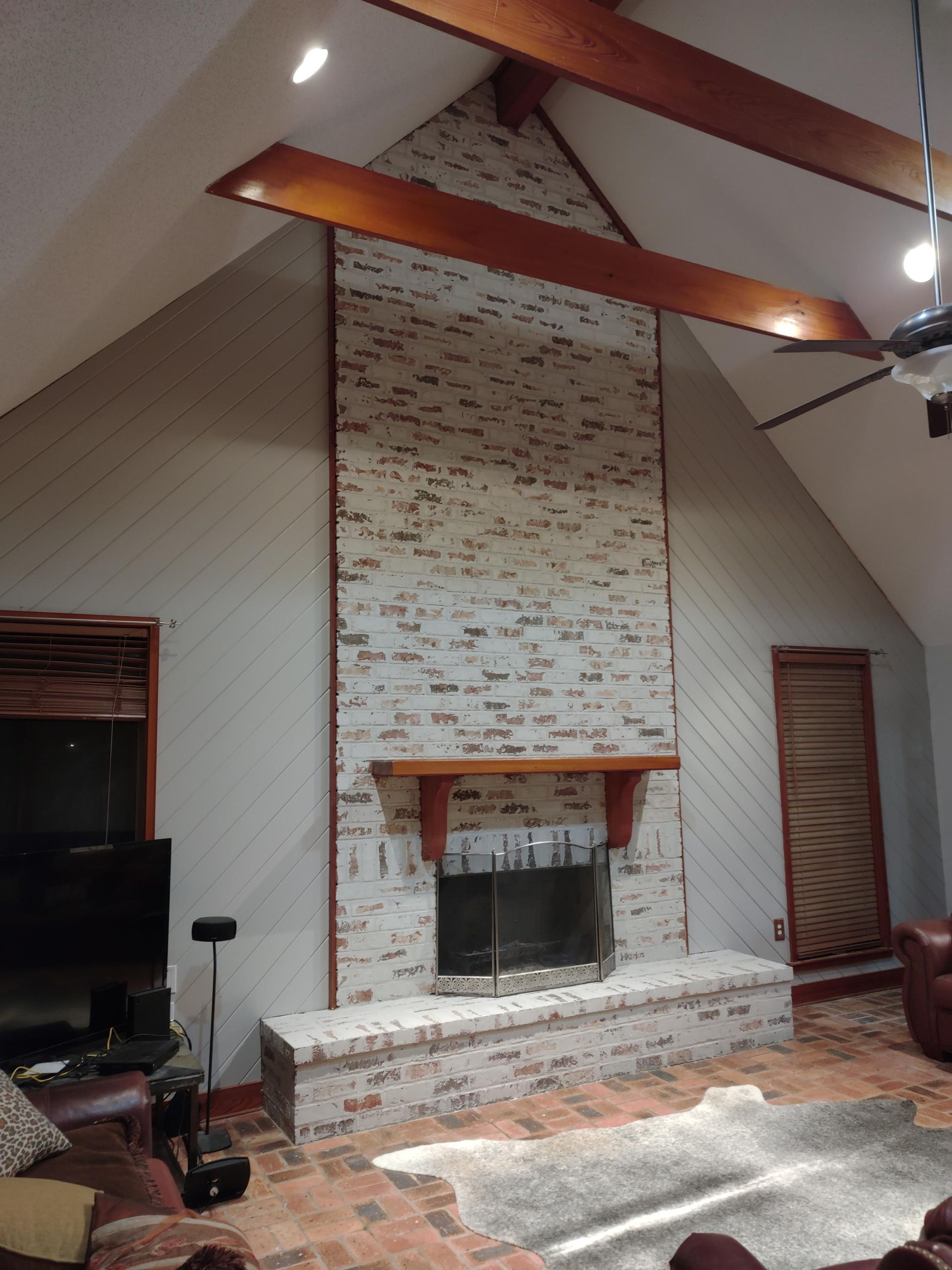 A living room with a fireplace and a vaulted ceiling
