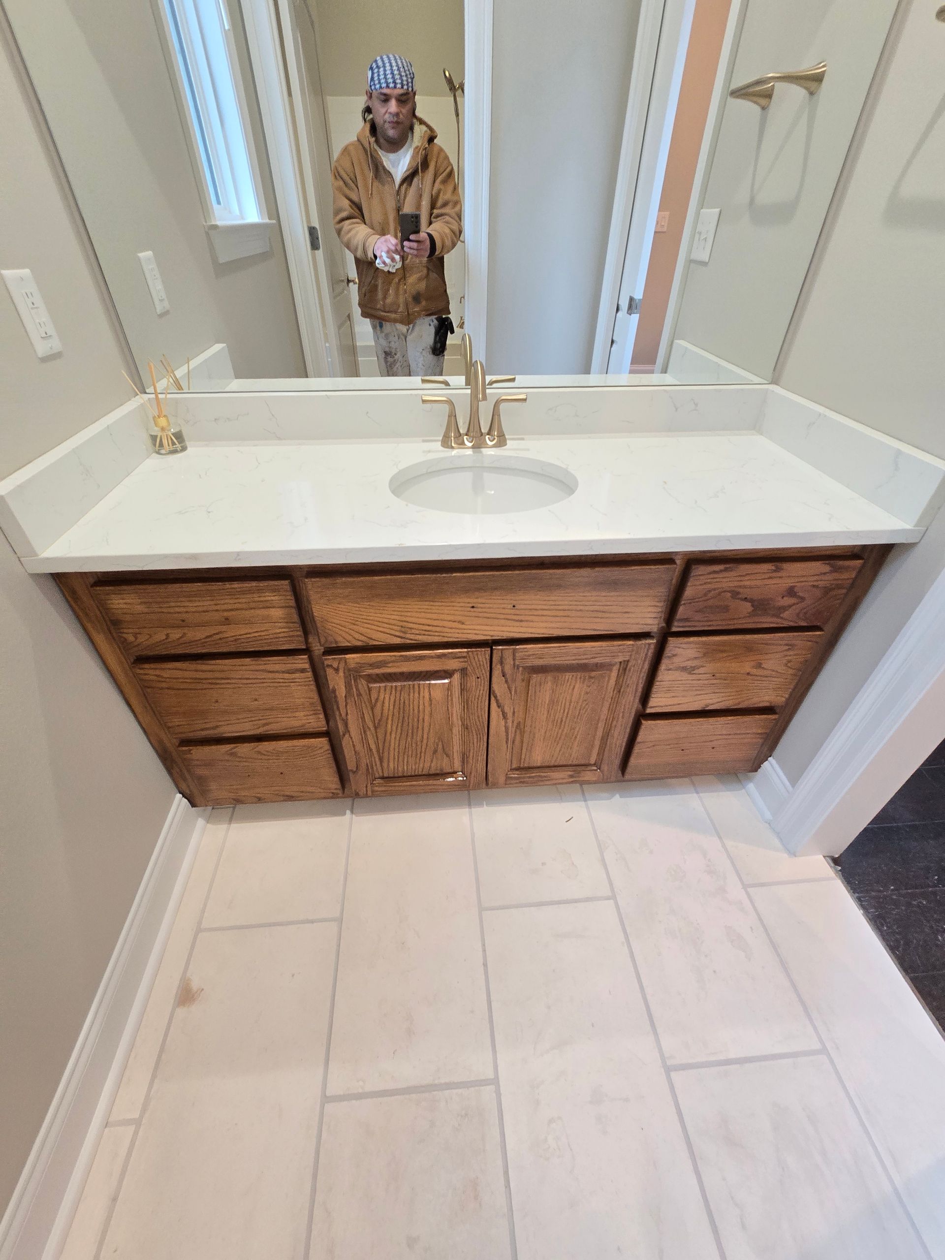 A man is standing in front of a bathroom sink and mirror.