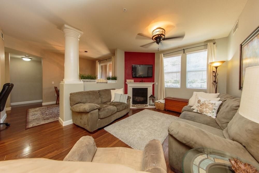 A living room with a couch , chair , fireplace and television.