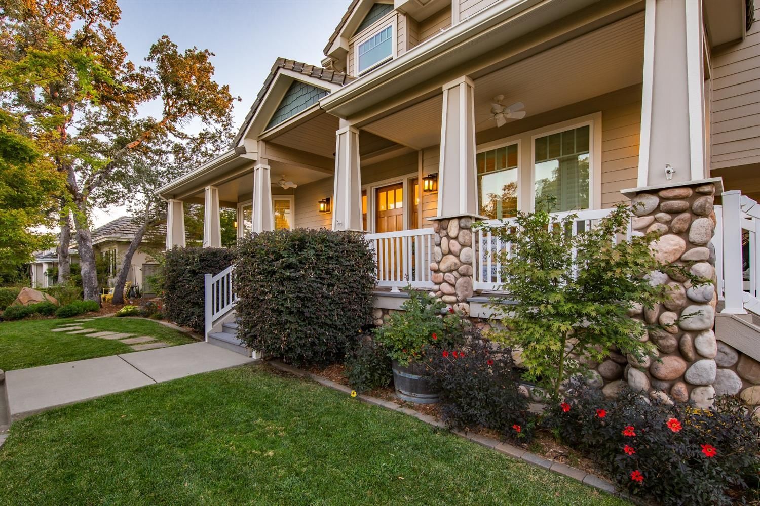 A large house with a large porch and a lush green lawn.