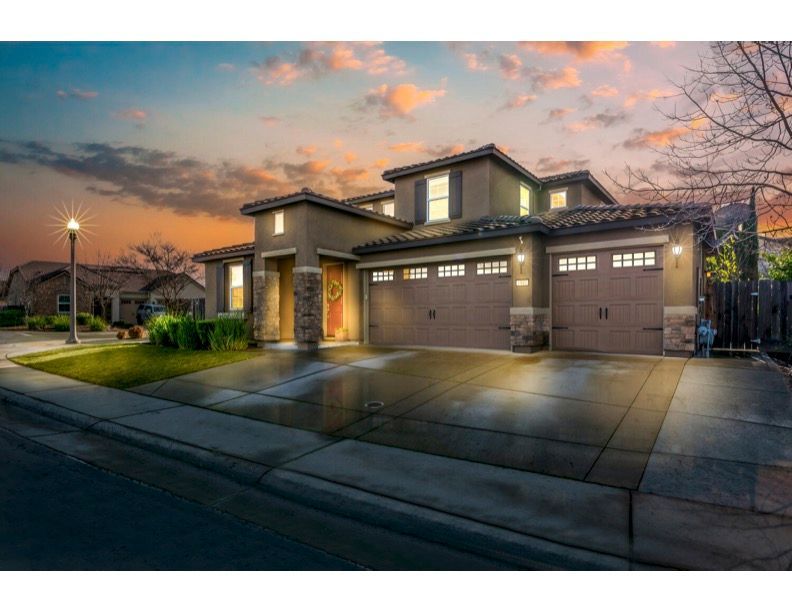 A large house with a lot of garage doors is for sale.