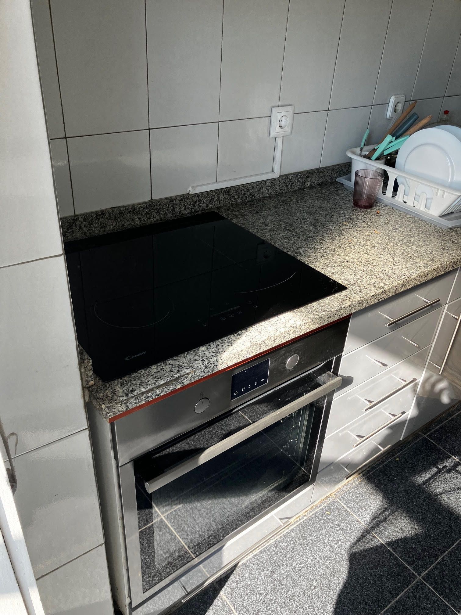 A kitchen with a stove top oven and granite counter tops