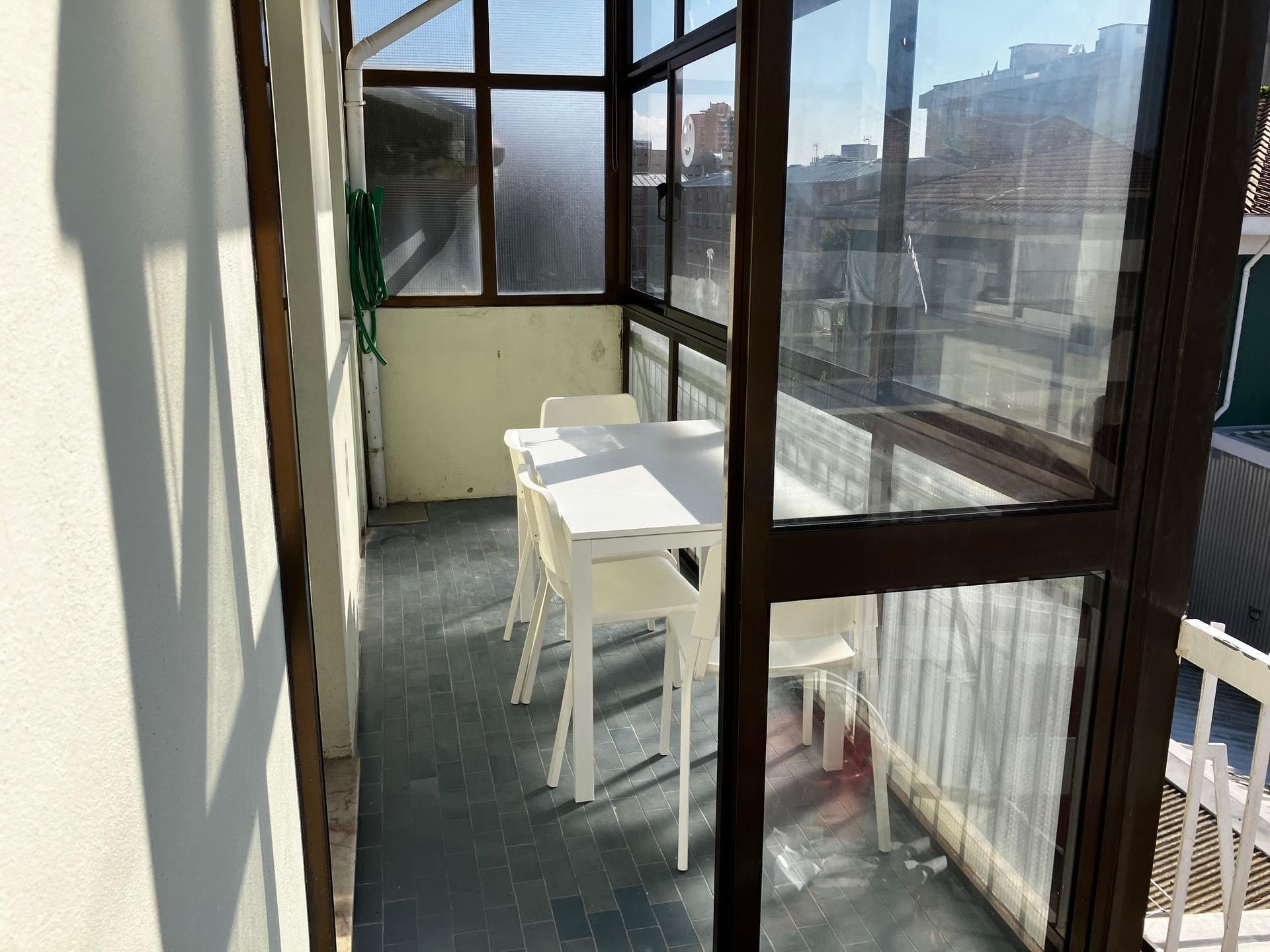 A balcony with a table and chairs in it