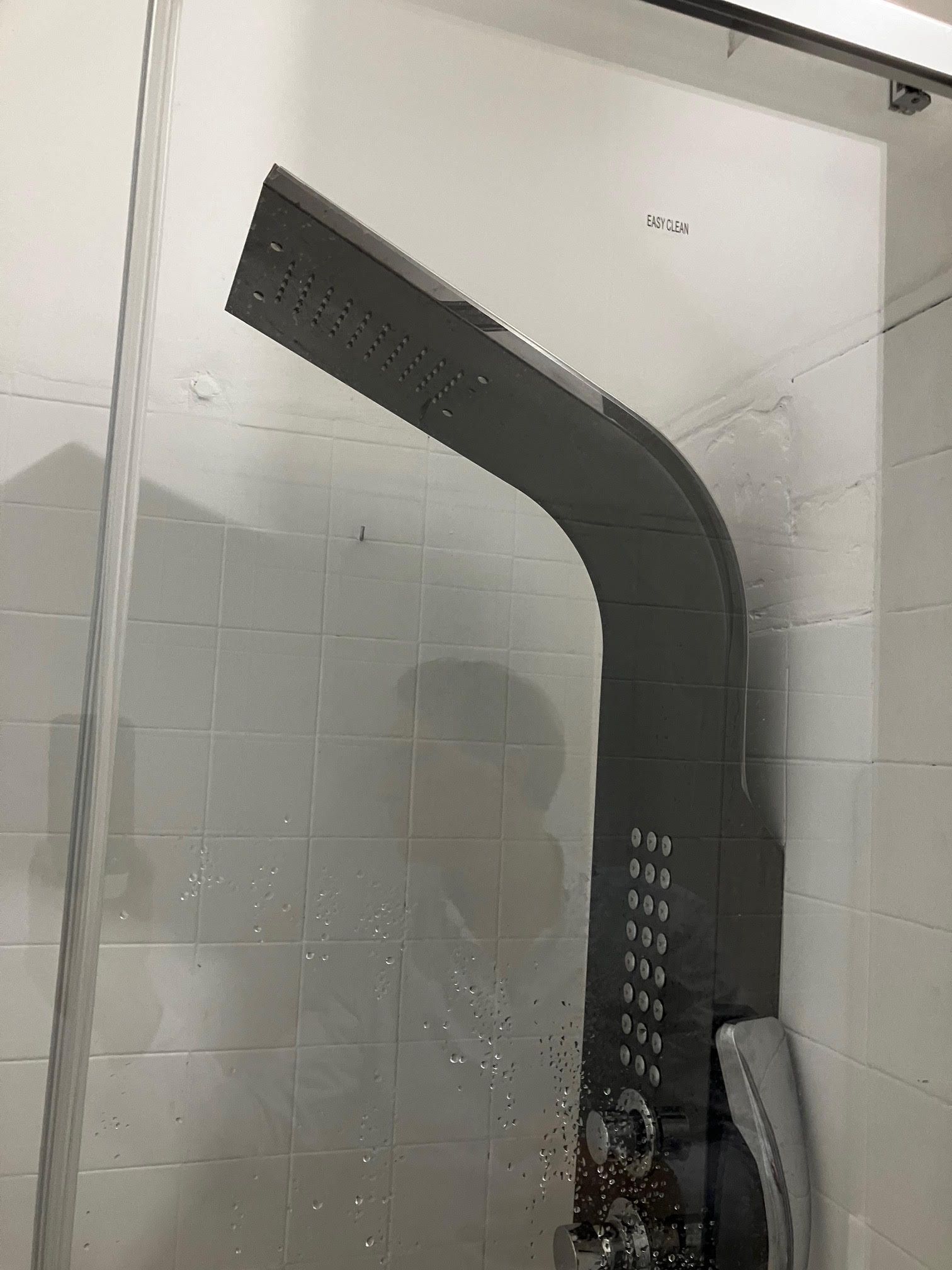 A shower head in a bathroom with water coming out of it.