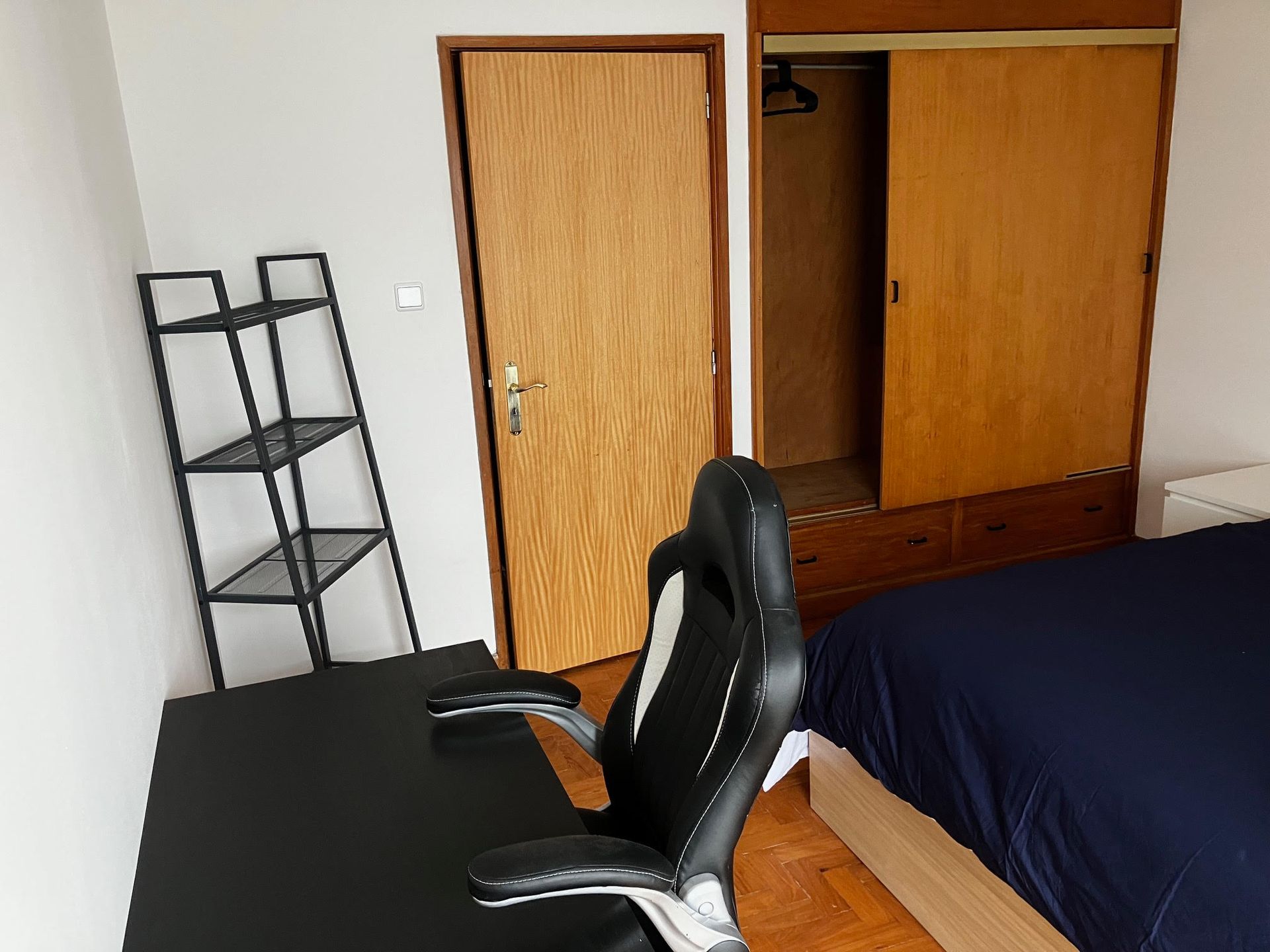 A bedroom with two beds and a desk and chair