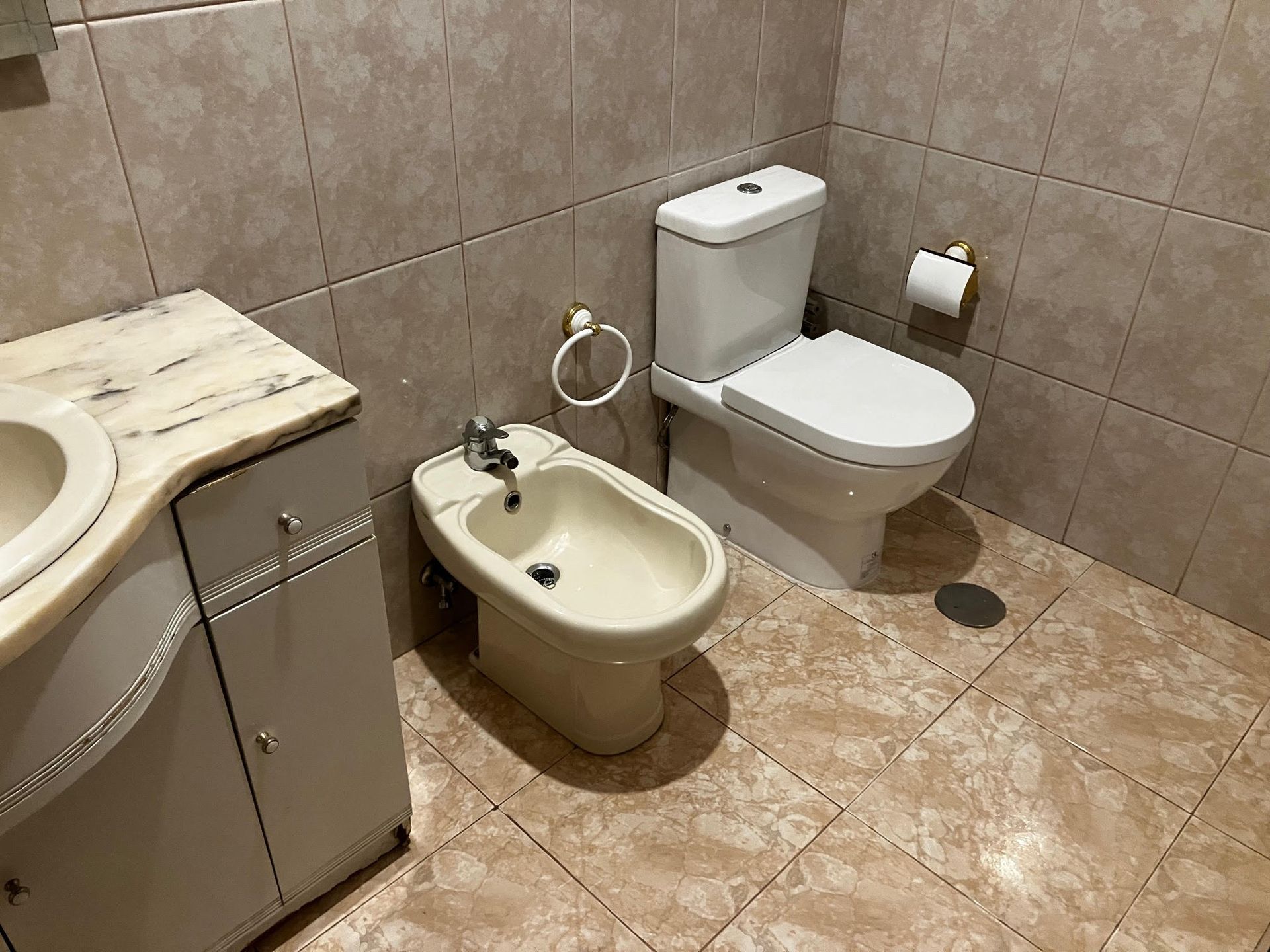 A bathroom with a bidet toilet and sink