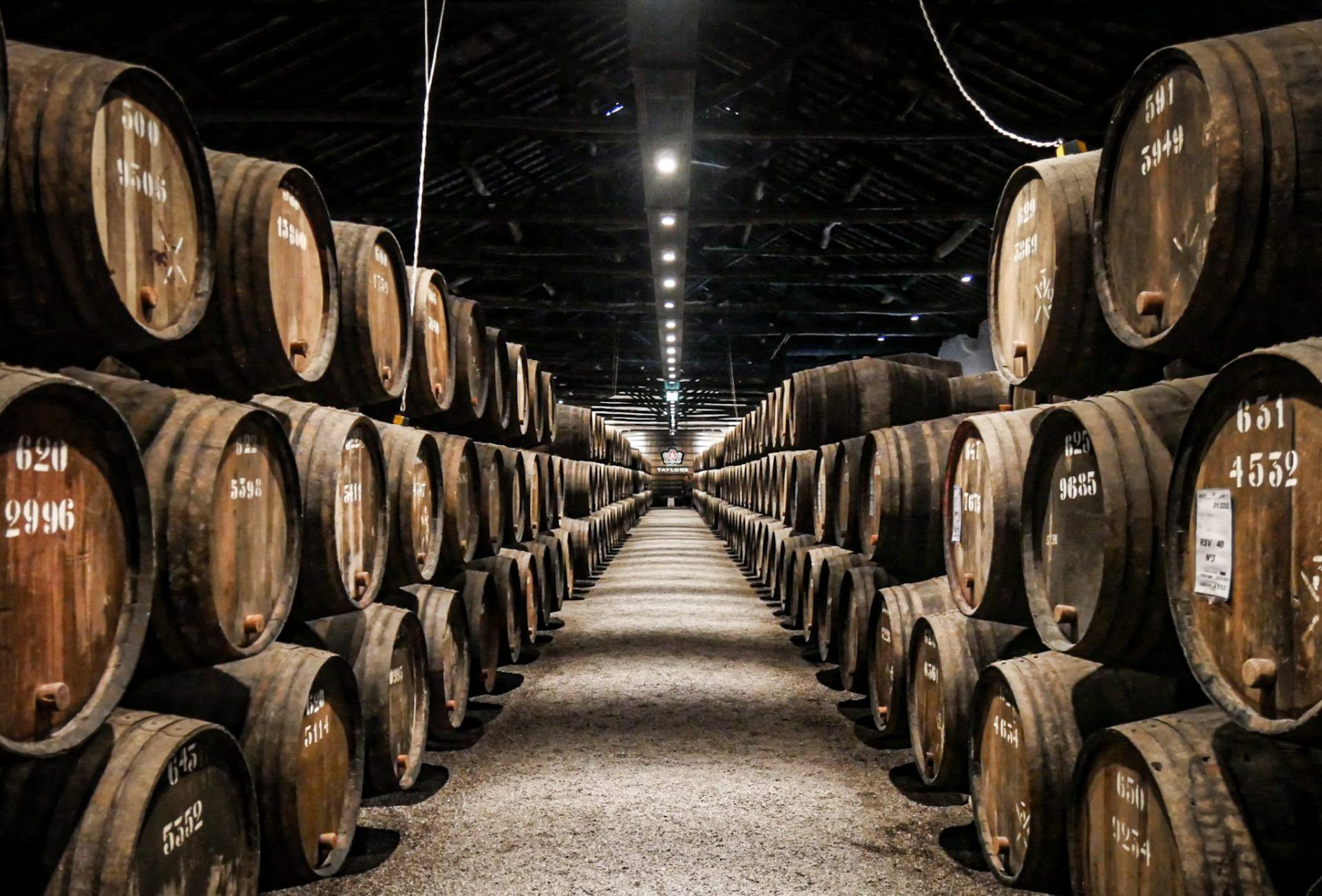 A row of barrels are lined up in a warehouse and one of them has the number 2196 on it