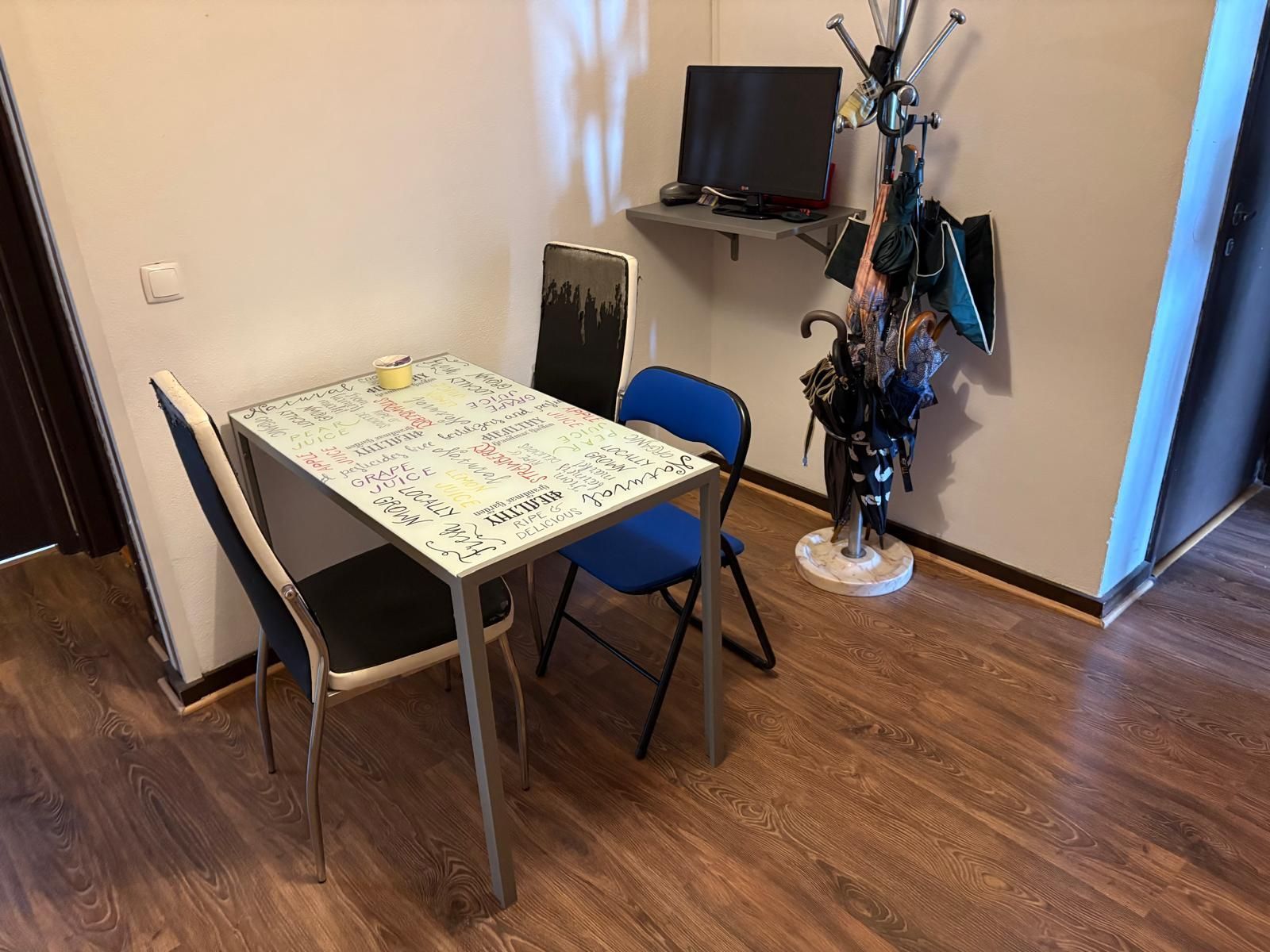 A room with a table and chairs and a tv