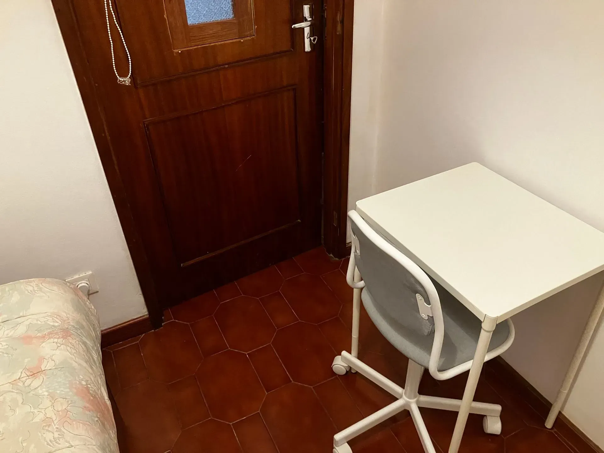 A small room with a desk and chair in it