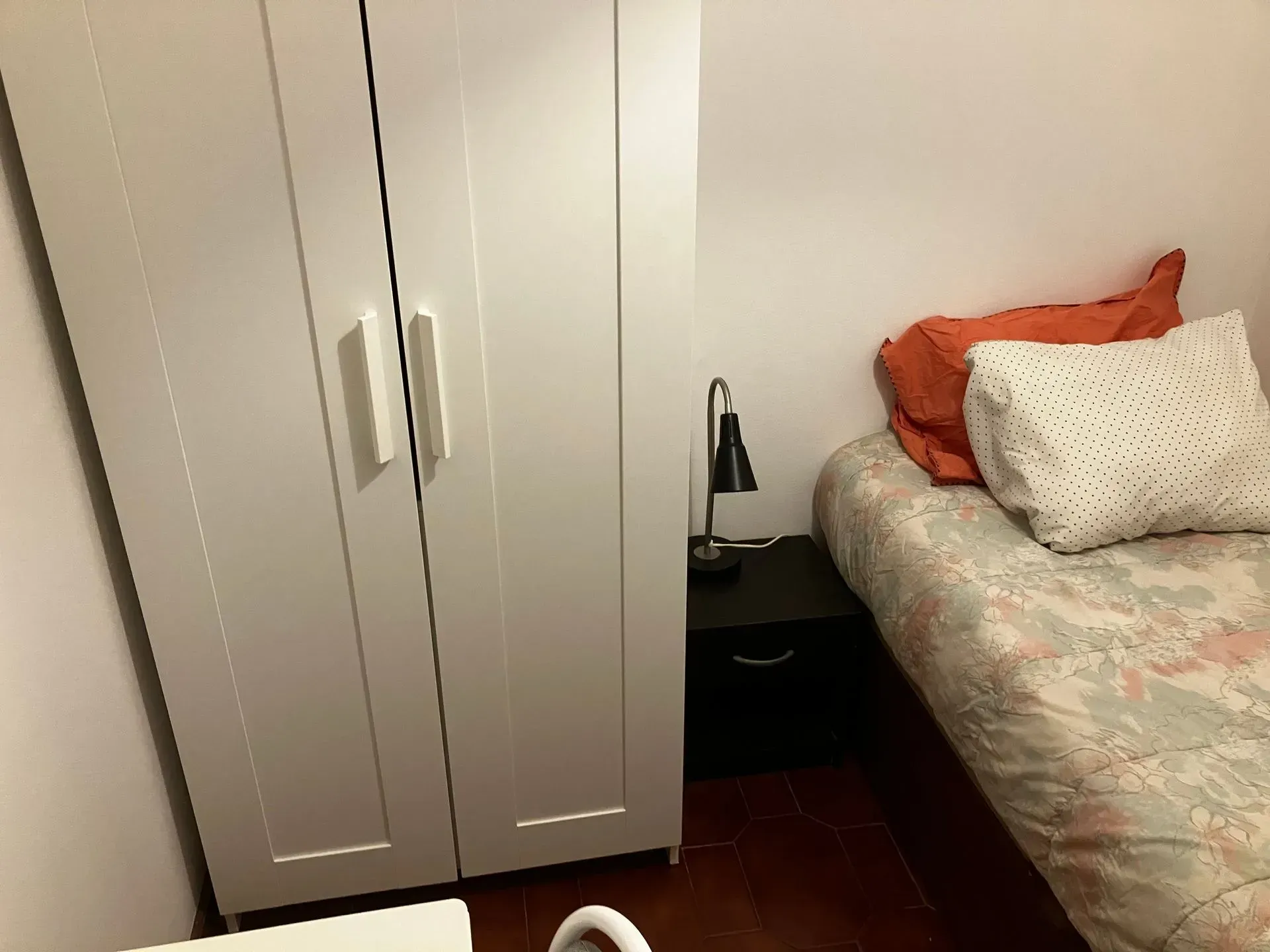 A small bedroom with a bed and a wardrobe