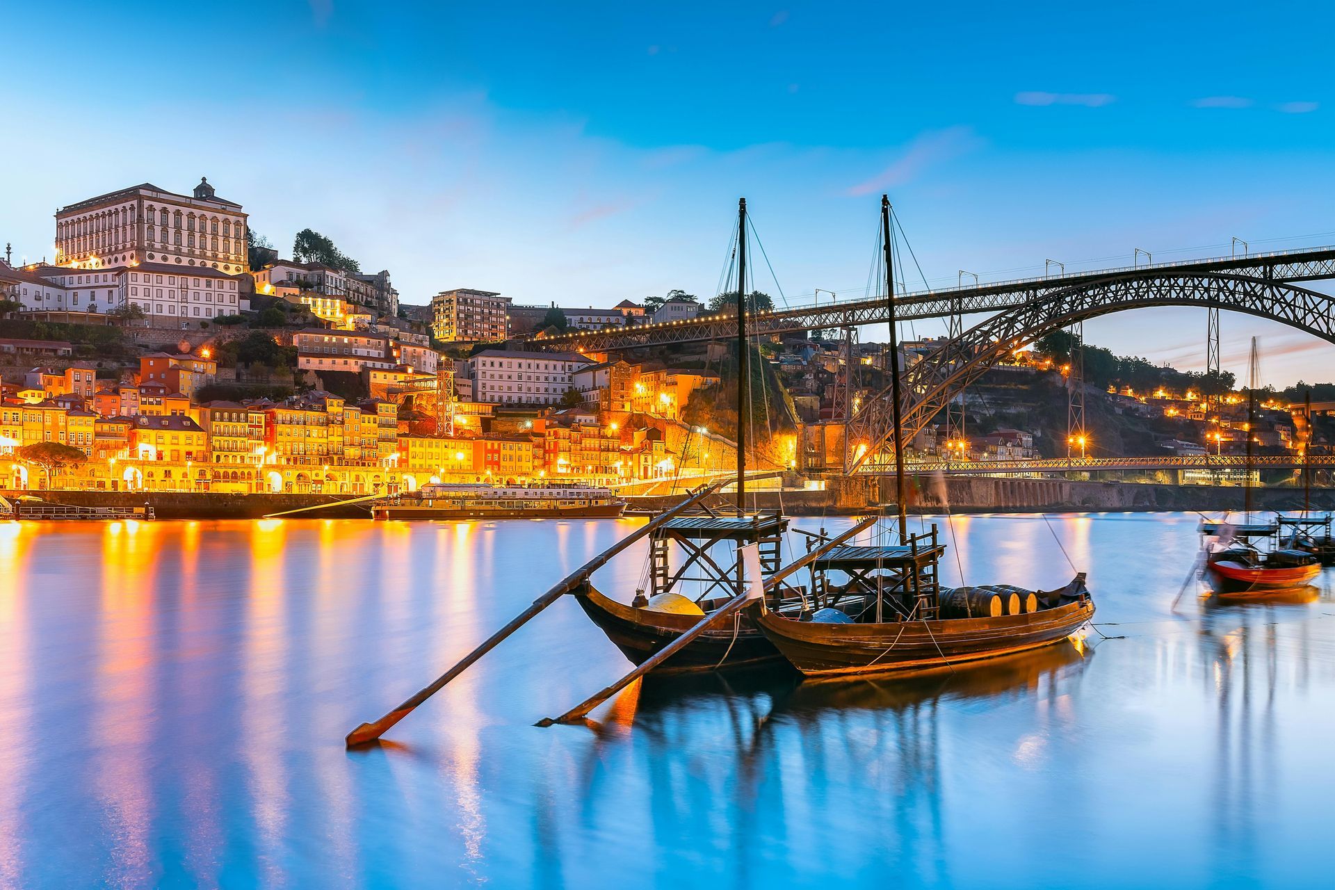 A boat is docked in the water with a city in the background