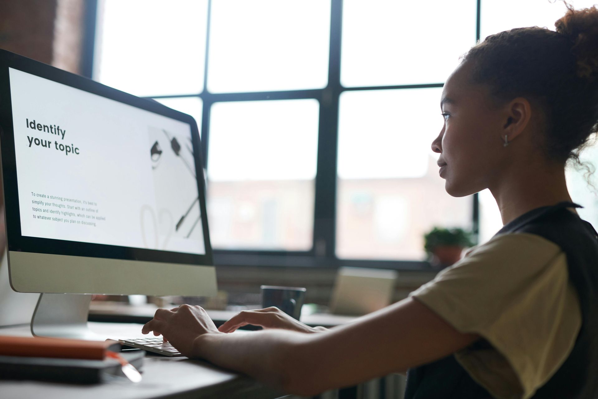 A woman is sitting at a desk using a computer