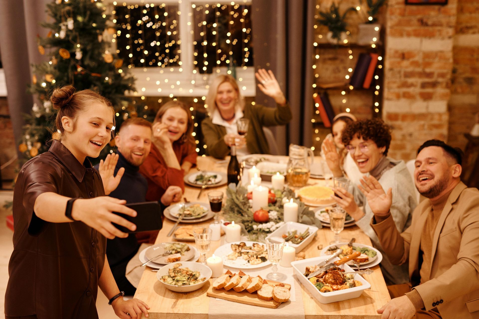 A group of people are sitting around a table eating christmas dinner.