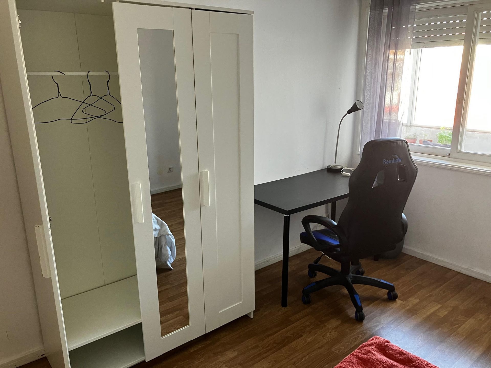 A room with a desk a chair and a wardrobe