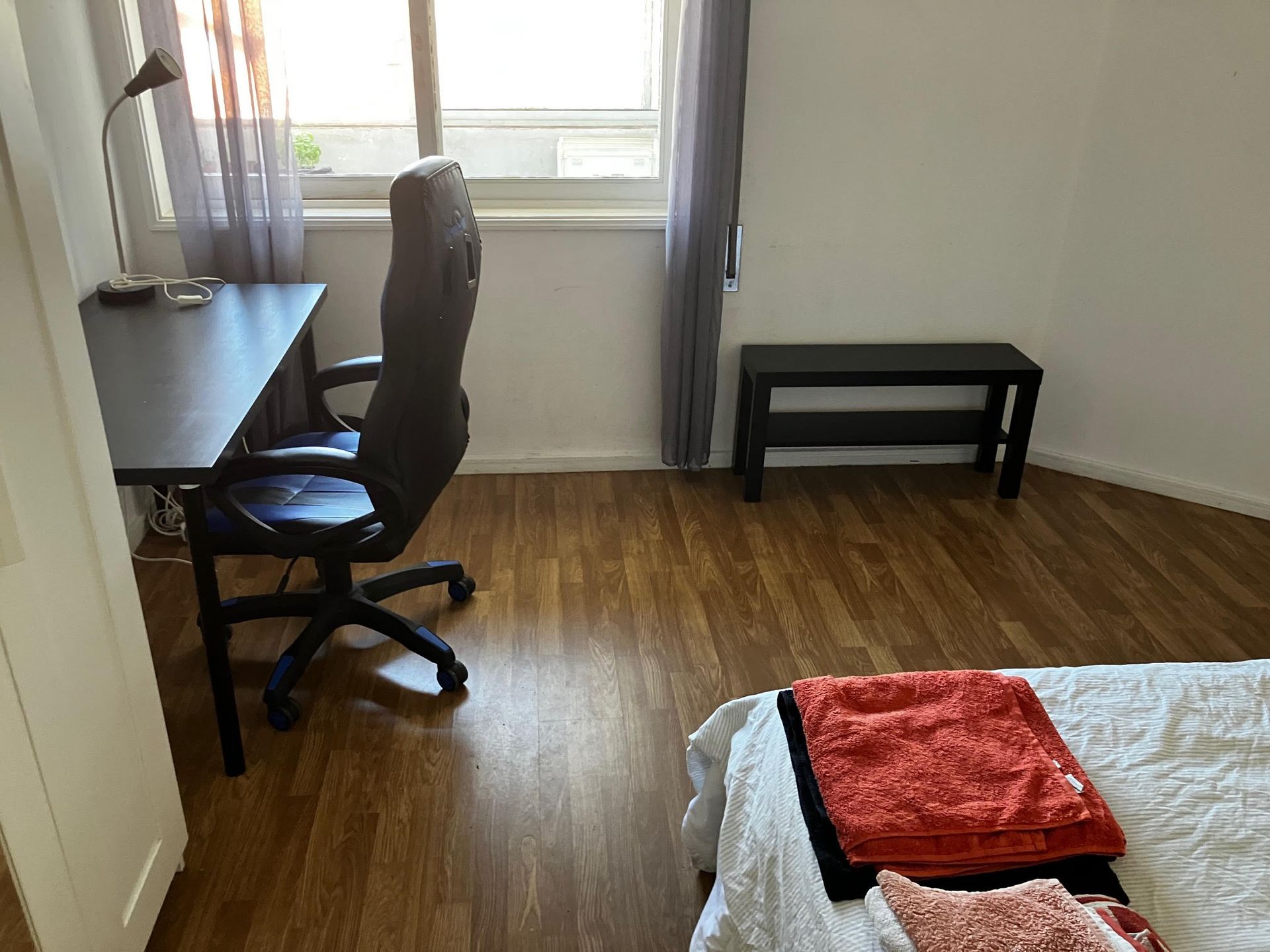 A bedroom with a desk chair and a bench