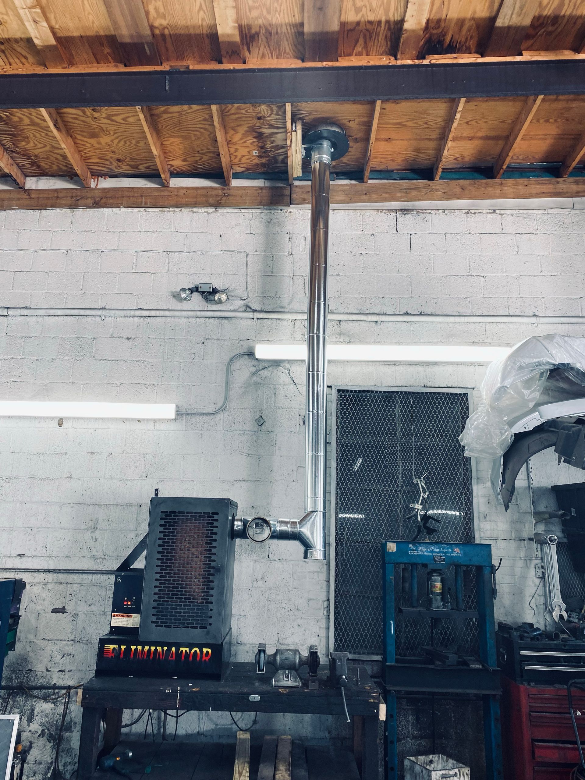 A metal pipe is hanging from the ceiling in a garage