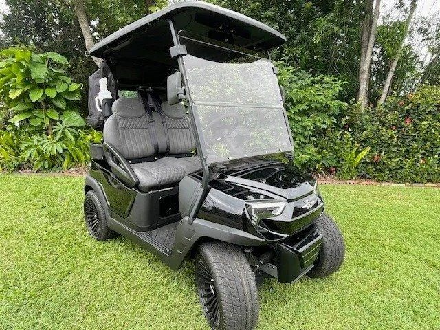 A Black Golf Cart is Parked on a Lush Green Field — Buggies & Batteries in Rockhampton, QLD