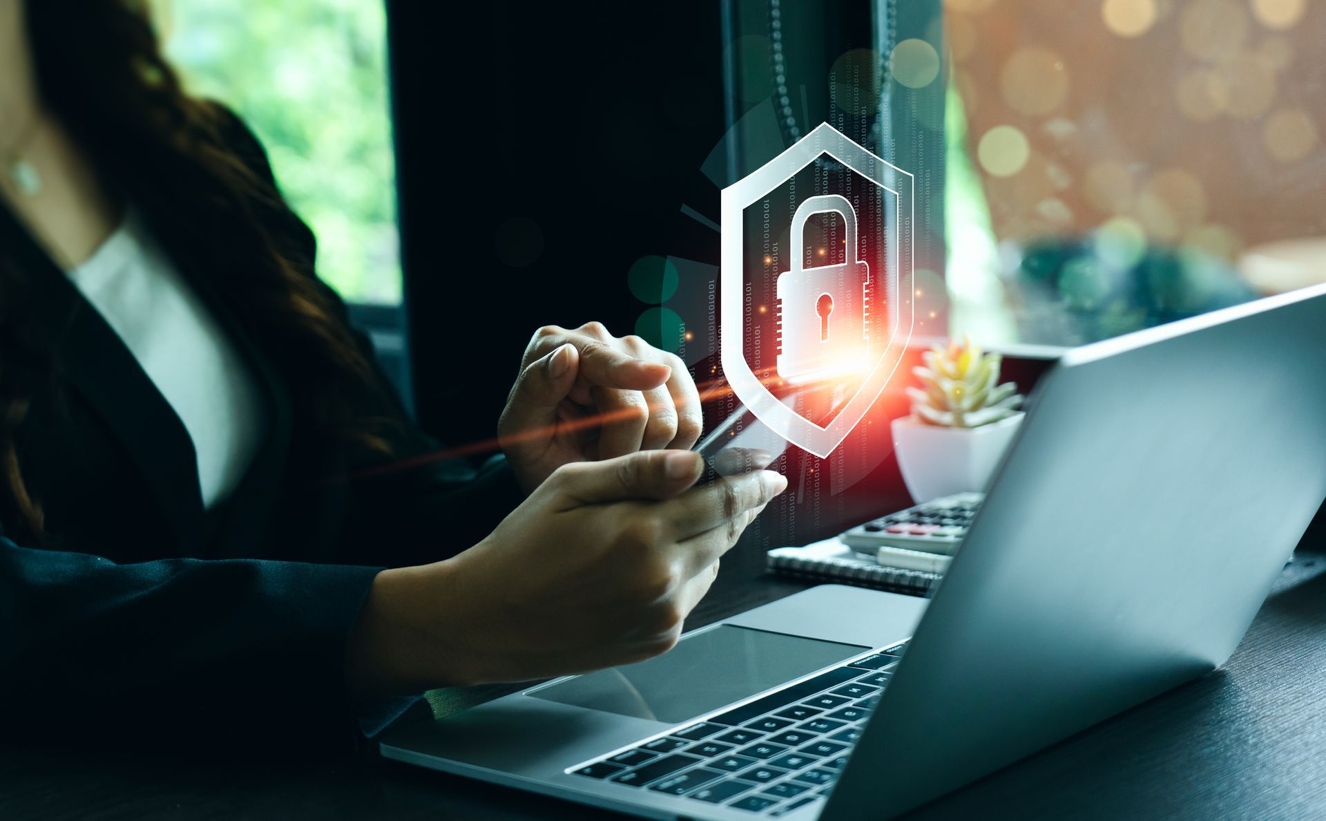 Woman using phone and laptop with security shield graphic overlay. Woman using phone and laptop with security shield graphic overlay.