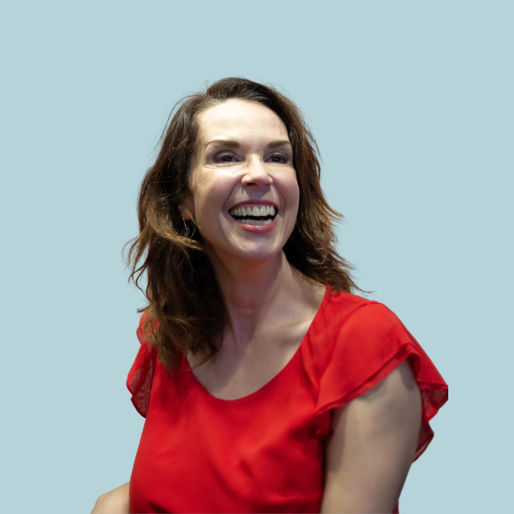 Woman in a red top laughing, looking to the side with a light blue background.