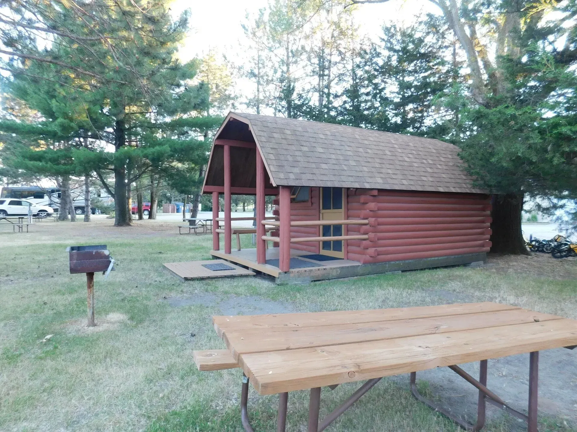 A log cabin with a picnic table in front of it