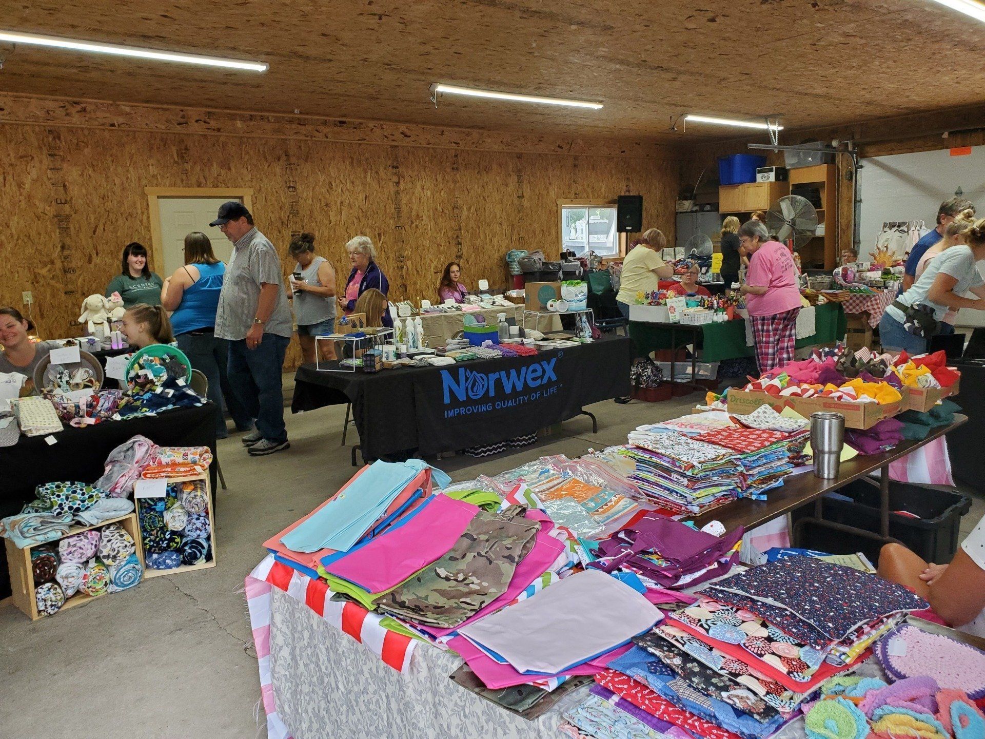 A group of people are standing around tables at a market.