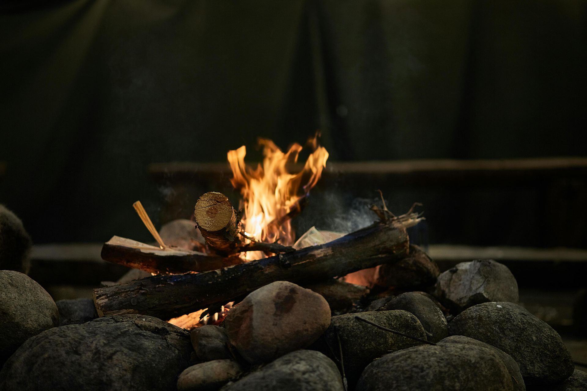 A campfire is sitting on top of a pile of rocks.