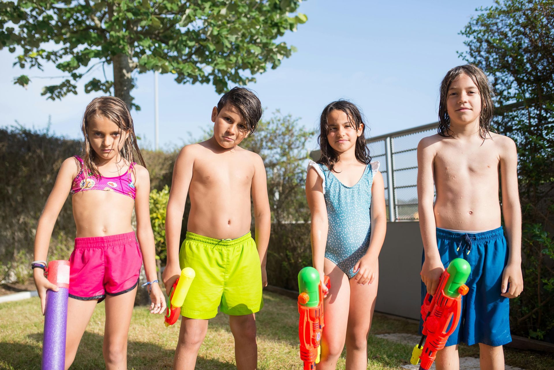 4 kids holding water guns