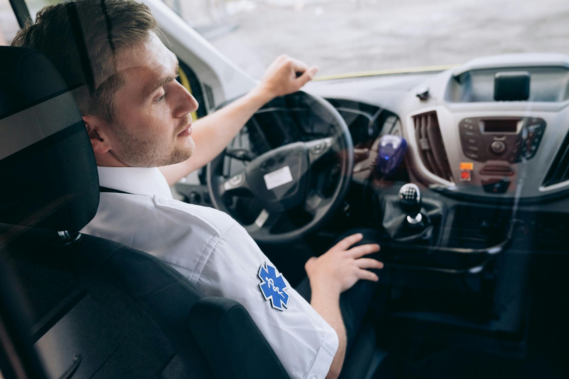 A man sitting in the front seat of an ambulance