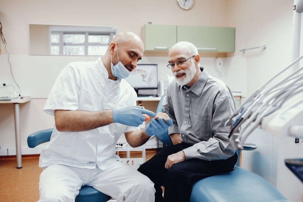 Dentist Showing Patient Their New Dentures — The Denture Care Group Sunshine Coast in Caloundra, QLD