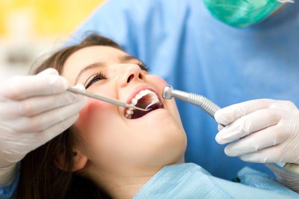 Woman at Dentist, Mouth Open, Receiving Dental Work — The Denture Care Group Sunshine Coast in Caloundra, QLD