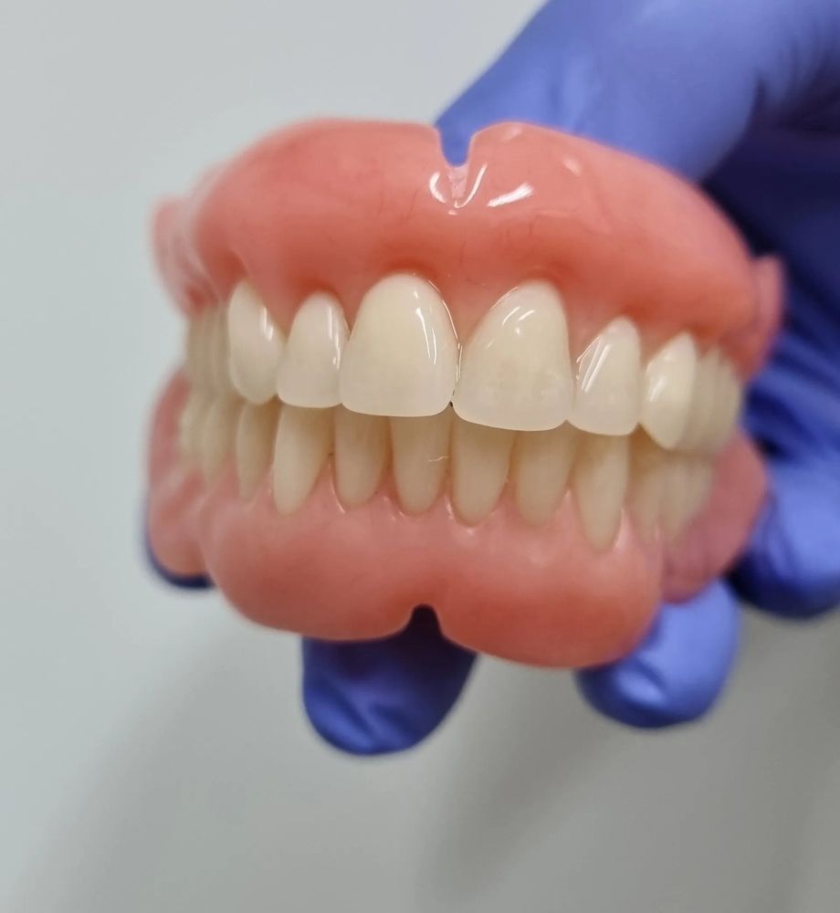 Dentist Holding Denture Replacement — The Denture Care Group Sunshine Coast in Caloundra, QLD