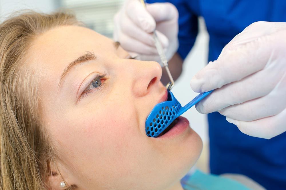 Dentist Using A Mouthguard On A Patient — The Denture Care Group Sunshine Coast in Caloundra, QLD