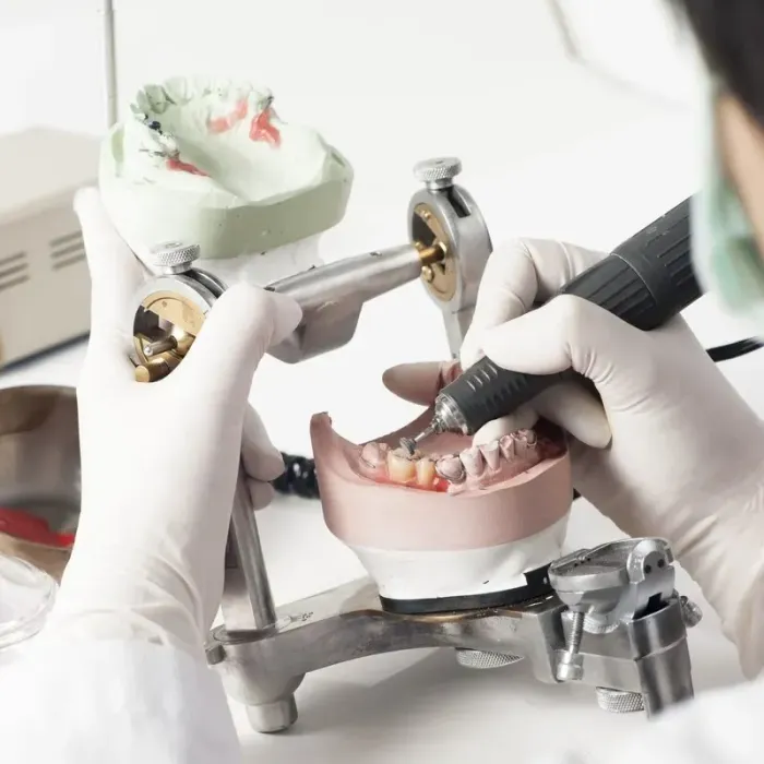 Dentist Working on a Dental Model With a Drill — The Denture Care Group Sunshine Coast in Caloundra, QLD