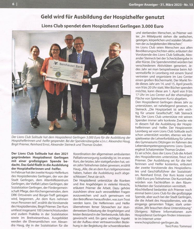 Eine Gruppe von Menschen steht nebeneinander und hält einen großen Scheck in den Händen.