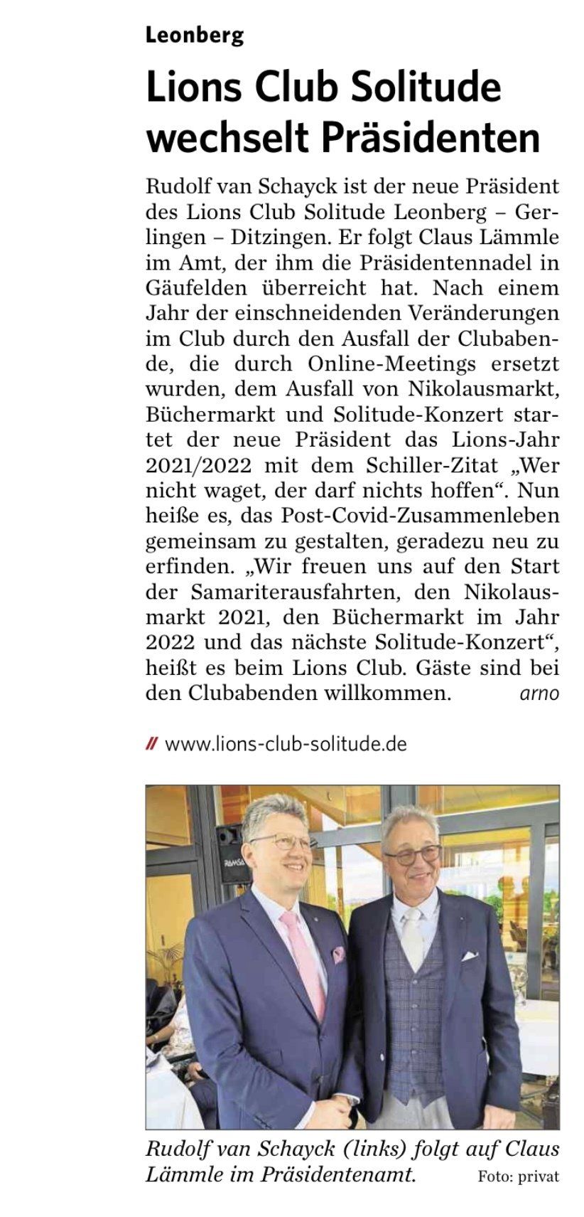 In einem Zeitungsartikel geben sich zwei Männer in Anzügen die Hand.