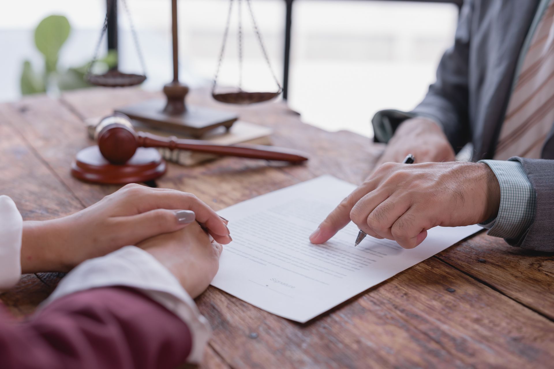 A lawyer discussing legal strategy and reviewing intellectual property documents with a client. A lawyer discussing legal strategy and reviewing intellectual property documents with a client.