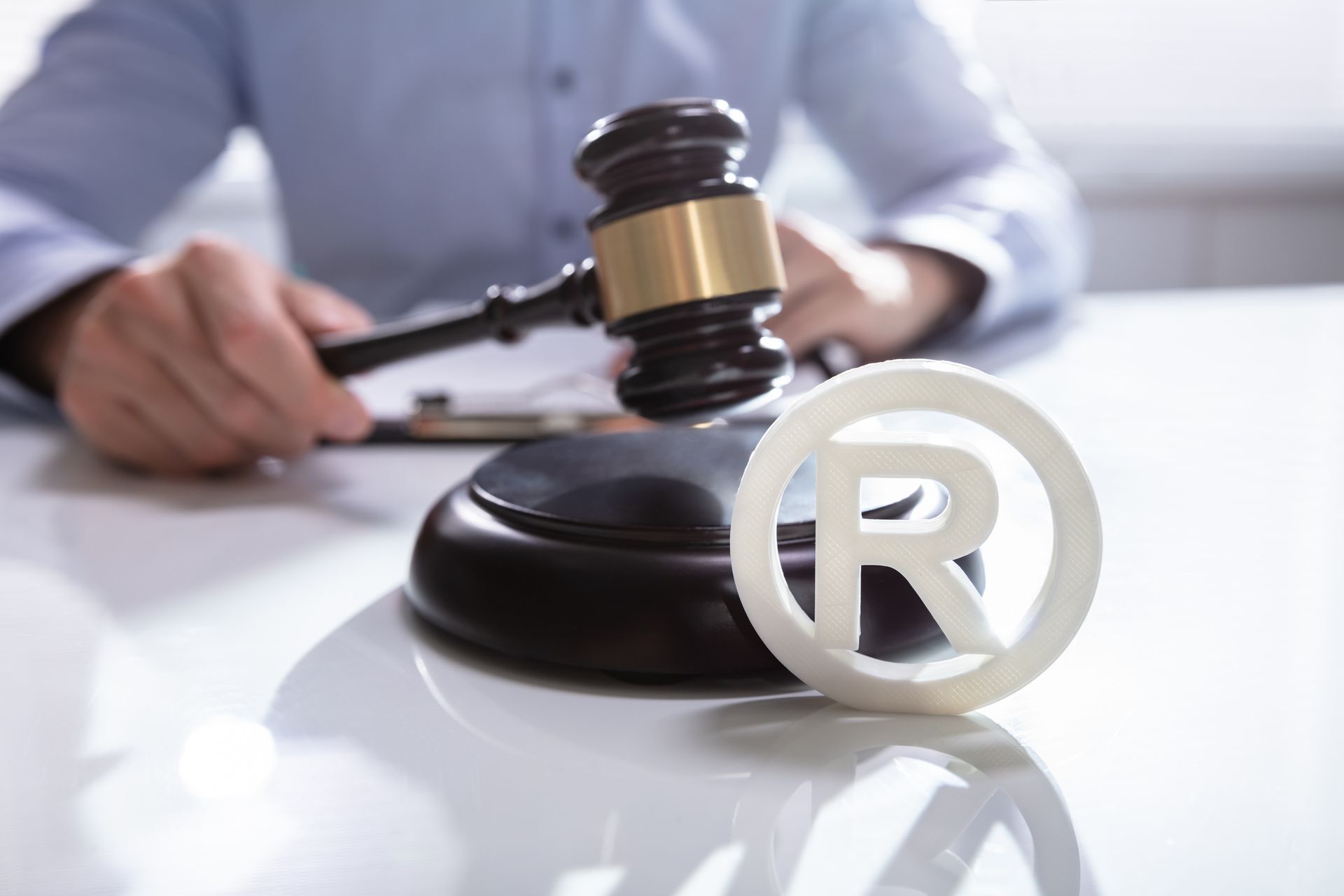 Registered trademark symbol and attorney holding gavel. Registered trademark symbol and attorney holding gavel.