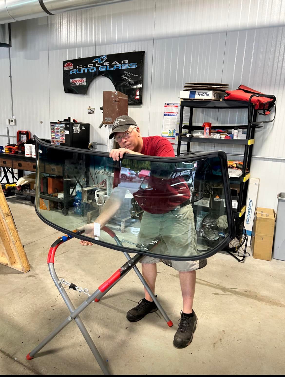 Two men are working on a white jeep in a garage.