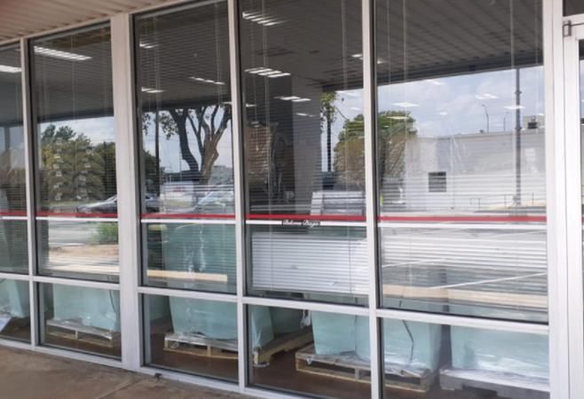 Empty storefront with large glass windows and a red-trimmed facade