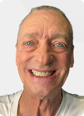 Man with blue eyes and wide smile, white shirt, close-up.