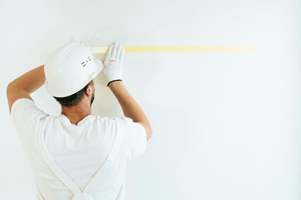 Professional painter in Sierra Vista AZ applying wall tape for sharp clean paint lines and flawless finish for interior walls