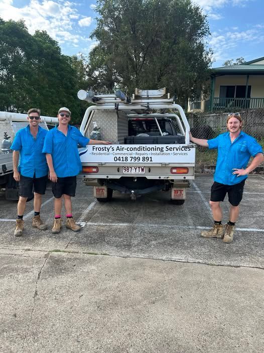 Four People in Blue Shirts Stand Next to a White Truck With — FrostyCo Air-Conditioning in Cannonvale, QLD