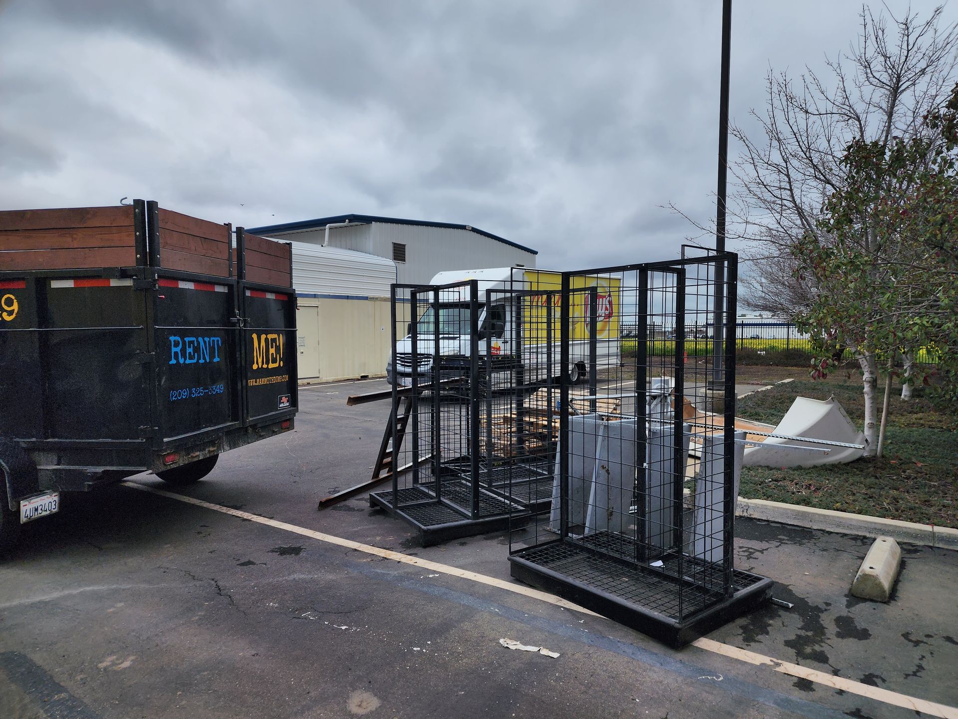 A 20 yard dumpster is parked in a parking lot next to a building.