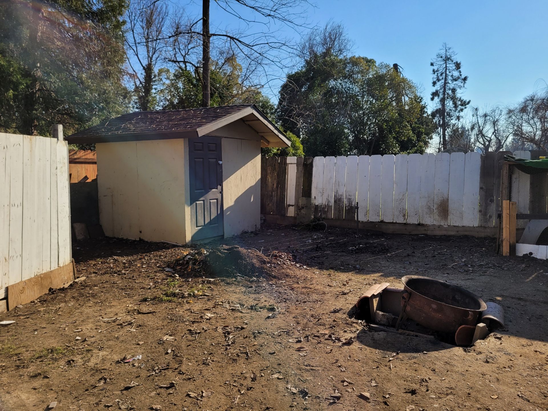 A backyard with a shed and a fire pit